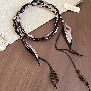 Close-up of retro ethnic waist chain with patterned fabric and wooden beads tassels.