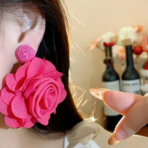 Macro view of elegant large pink chiffon rose earring worn on an Asian model's ear