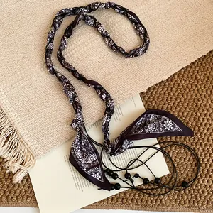 Close-up detail of retro ethnic fabric waist chain with paisley pattern and beads