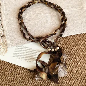 Close-up of retro ethnic fabric belt with woven texture and wooden bead tassels