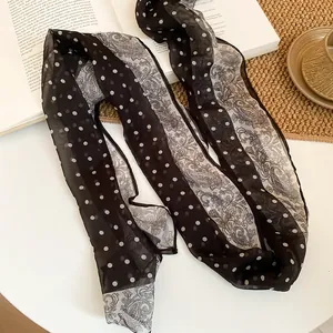 Detailed view of the vintage paisley and polka dot pattern on a soft chiffon fabric belt
