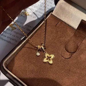Elegant gold-plated flower pendant necklace with sparkling zircon on a brown velvet box