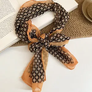 Close-up detail of a retro style polka dot and stripe pattern chiffon scarf tied in a bow