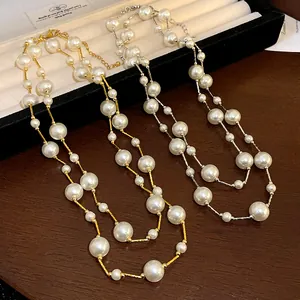 Detalle de elegantes collares de doble capa de perlas de vidrio en madera
