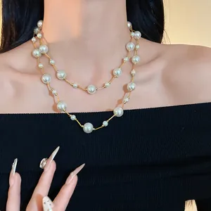 Primer plano de un elegante collar de doble capa con brillantes perlas de vidrio blanco.
