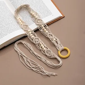 Close-up of handmade macrame belt with wooden beads and vintage bohemian style tassels