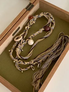 Detailed view of bohemian woven belt with wooden beads in decorative box