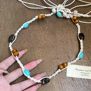 Close-up of ethnic style hand-woven cord belt with turquoise and wooden beads