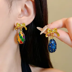Detailansicht französischer Vintage-Ohrringe mit Goldschleife und Emaille-Eiern