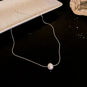 Vue macro d'une seule perle d'eau douce sur un collier à chaîne fine argentée