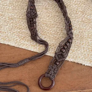 Macro detailed view of bohemian macrame waist chain with wooden beads and round ring