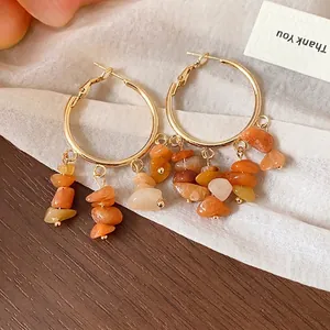 Ethnic style gold hoop earrings featuring irregular natural orange stone tassel clusters