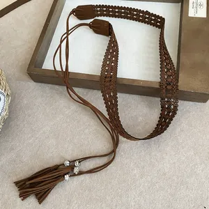 Detailed macro shot of vintage boho waist chain with hollow patterns and soft suede tassels