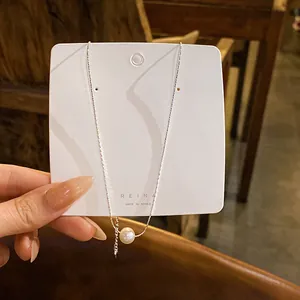 Collier avec pendentif perle d'eau douce minimaliste sur chaîne argentée, vue macro