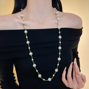 Elegante collar largo de perlas sintéticas en una modelo como accesorio de moda chic