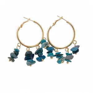 Elegant gold hoop earrings featuring irregular blue stone charms in bohemian style