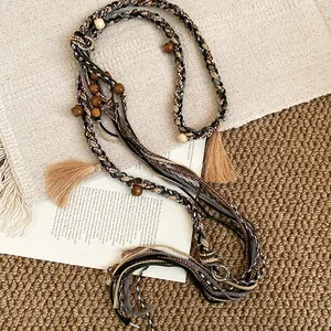 Detail showing the intricate braided fabric, wooden beads, and tassels of this belt