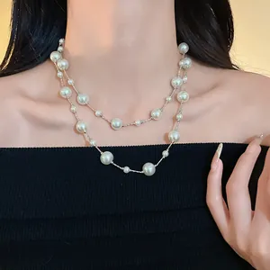 Elegante collar de perlas de imitación blancas de dos hilos en el cuello de una modelo