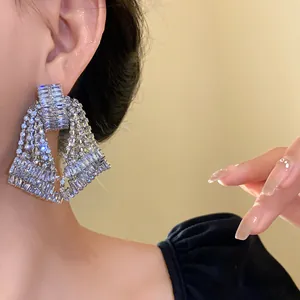 Elegant close-up shot of silver needle bow tassel earrings with sparkling rhinestones
