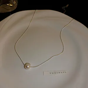 Détail d'un élégant collier de perles d'eau douce sur une fine chaîne en argent