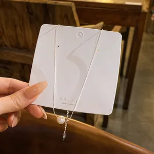 Vue rapprochée d'un collier en argent minimaliste avec une perle d'eau douce blanche