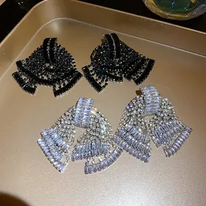 Close-up detail of luxury rhinestone bow tassel earrings in black and clear crystals