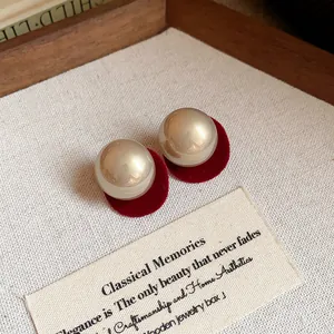 Elegant champagne pearl stud earrings with red velvet base and silver needles design