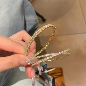 Elegant gold-plated twisted bangle featuring sparkling zircon stone pavé setting.