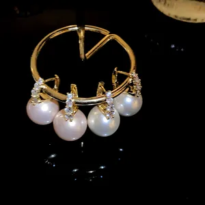 Detail view of French vintage gold hoops with crystals and dangling pink and white pearls