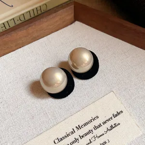 Minimalist round pearl stud earrings in elegant champagne gold finish for high-end fashion