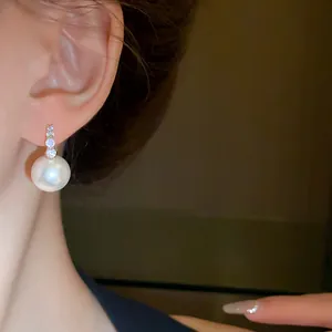 Elegant close-up detail of a French retro pearl earring with sparkling diamond accents