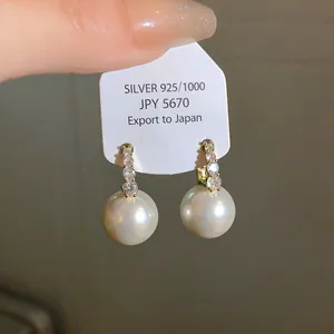 Close-up of elegant French vintage pearl drop earrings with sparkling rhinestones