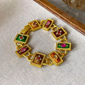 Nahaufnahme einer goldenen Vintage-Halskette mit buntem Emaille- und Kristalldetail