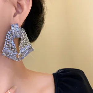 Close-up of sparkling bow tassel earrings encrusted with baguette-cut rhinestones