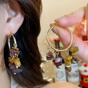 Detail view of bohemian irregular stone tassel hoop earrings with elegant gold finish.