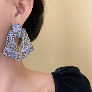 Detailed macro view of elegant silver-toned tassel earrings with shimmering rhinestones.