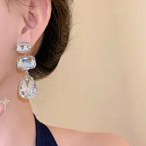 Primo piano di eleganti orecchini in argento con brillanti strass quadrati e a goccia