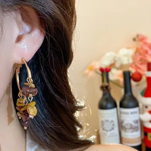 Close-up view of bohemian hoop earrings featuring colorful irregular stone pendants