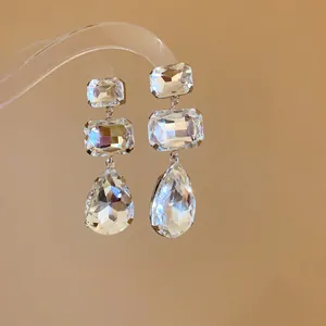 Primo piano di eleganti orecchini a goccia con cristalli quadrati sfaccettati