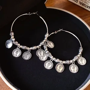 Dettaglio di orecchini a cerchio vintage con ciondoli moneta Queen Elizabeth II
