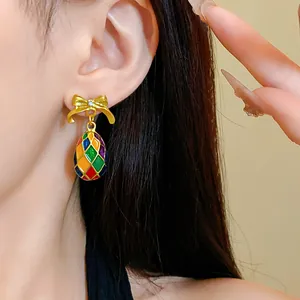 Nahaufnahme von Vintage-Schleifenohrringen mit bunten Harlekin-Emaille-Wassertropfen-Detail.