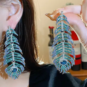 Elegant peacock feather drop earrings embellished with sparkling green and blue crystals