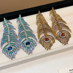 Exquisite rhinestone feather earrings in blue and gold finish for a luxury look