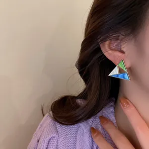Geometric triangle stud earrings with multi-colored enamel on Asian model