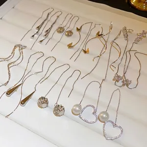 Elegant tassel ear threads with heart, pearl, and zircon charms in silver and gold