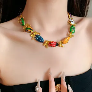 Detailansicht einer Vintage-Emaille-Halskette mit bunten Anhängern und Schleifengliedern.