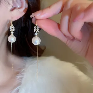 Detail view of elegant long tassel pearl earrings with sparkling zircon accents for women