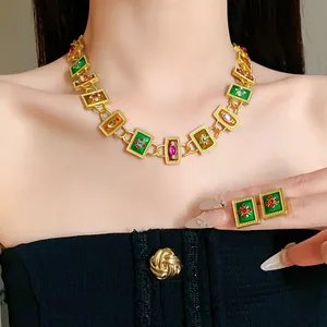Nahaufnahme von Vintage-Schmuckset in Gold mit Emaille-Blumendetails im französischen Retro-Stil