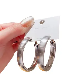 Orecchini a cerchio larghi in argento spazzolato su una scheda di gioielli moda