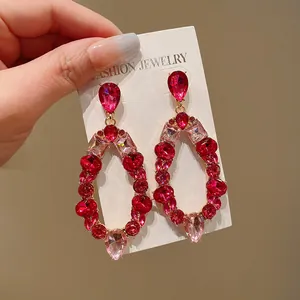 Close-up view of luxury red and pink crystal geometric oval drop earrings on display